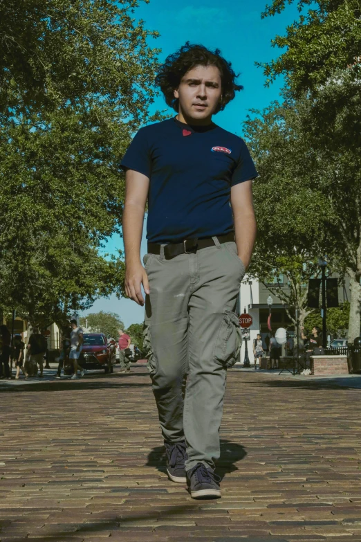 the young man is walking down the brick walkway