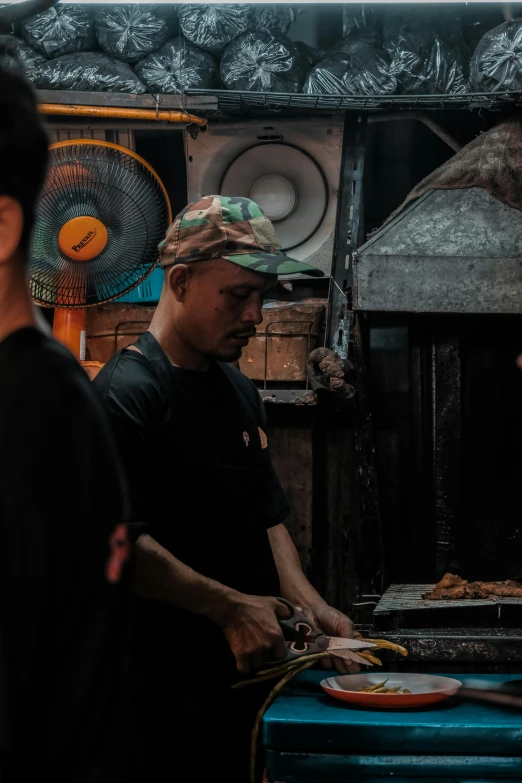 a man making a sandwich while standing in front of other men