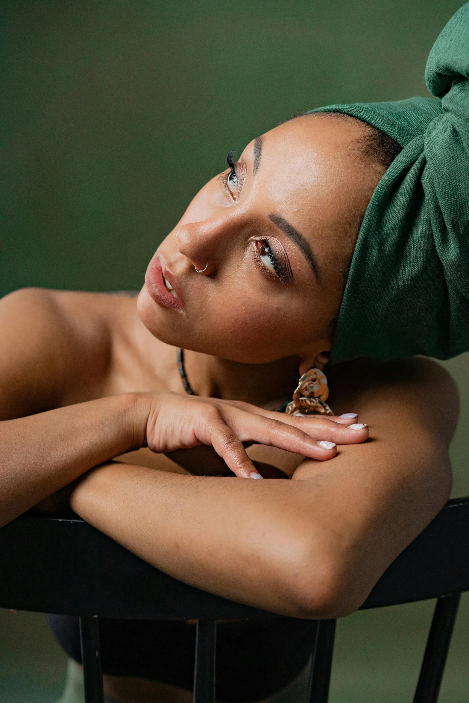 a woman wearing a green head band is posing for a picture