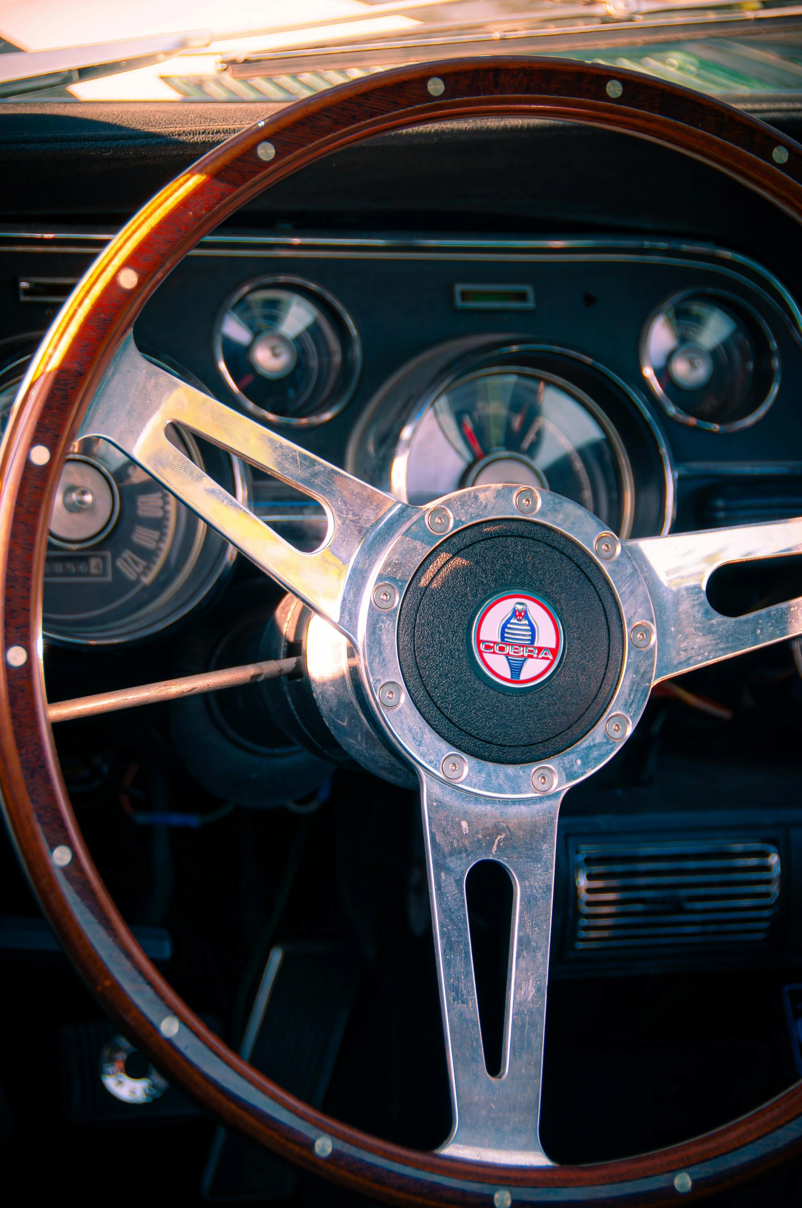 a steering wheel of a car with wooden dash boards and dashboard lights