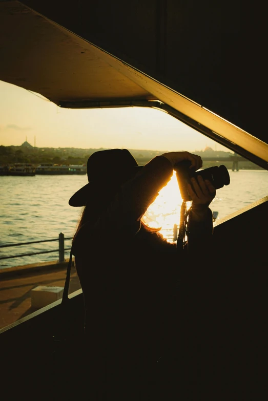 man watching the sun set with his telescope