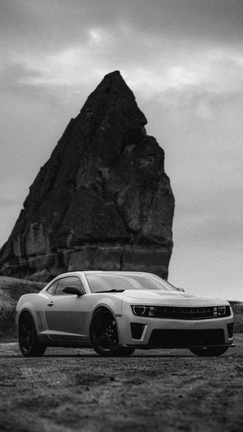 the chevrolet camaro ss is parked near a rocky outcropping