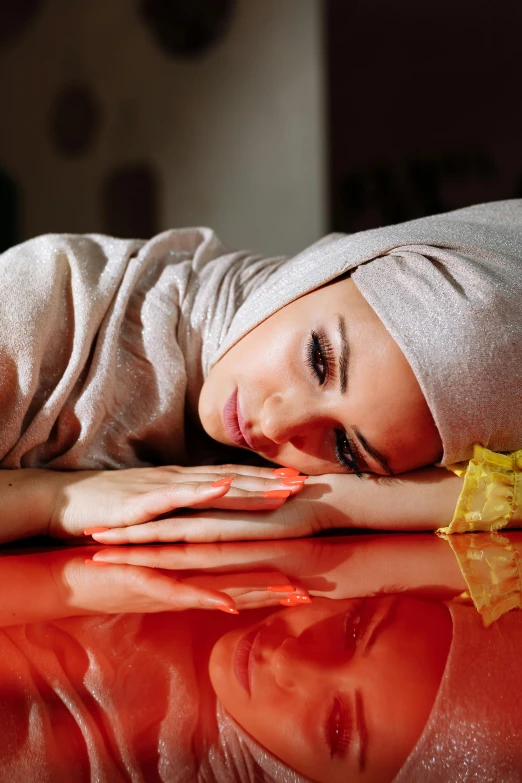 a woman in a towel lays on the surface of a table