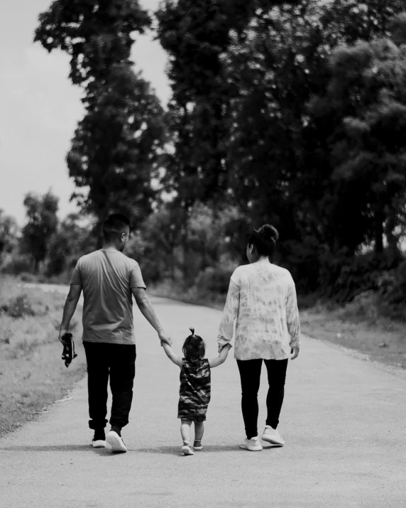 a man and a woman holding hands walking down the street