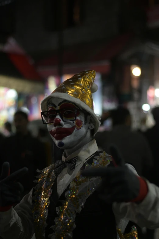 a person dressed in carnival wear standing on a city street at night