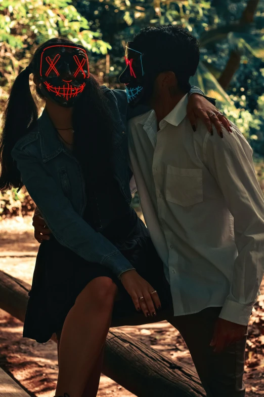 a man is sitting in the middle of a woman's head, with a halloween mask on