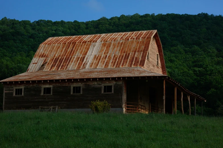an old barn with rusty tin roof and windows