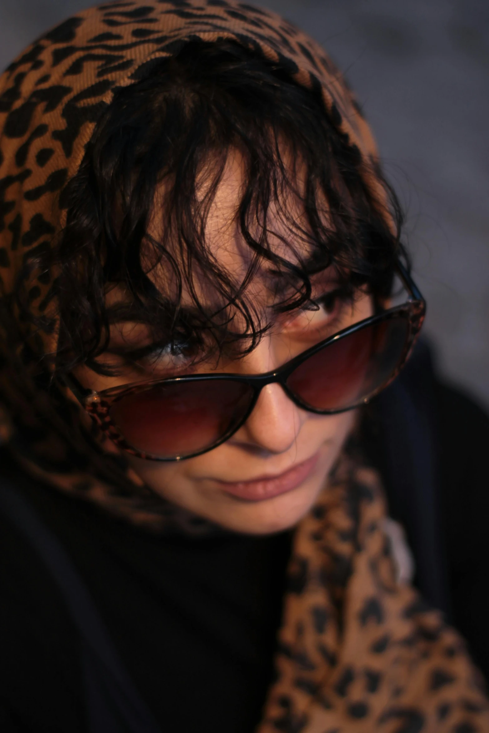 a young woman in glasses and a leopard print scarf