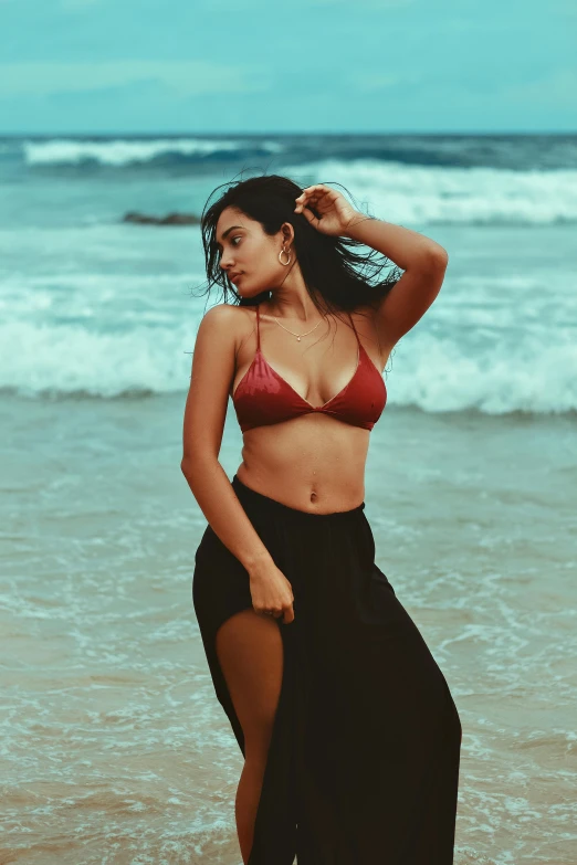 a young woman in a bikini posing on the beach