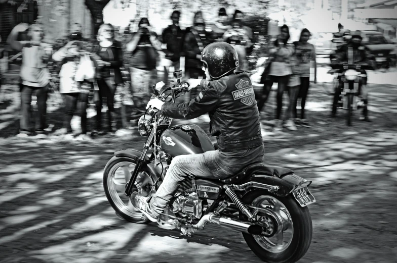 a man riding on the back of a motorcycle with a crowd