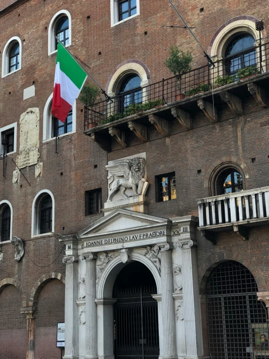 an italian flag flying in front of an old building
