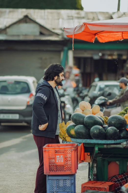 a person standing next to a table with fresh produce on it