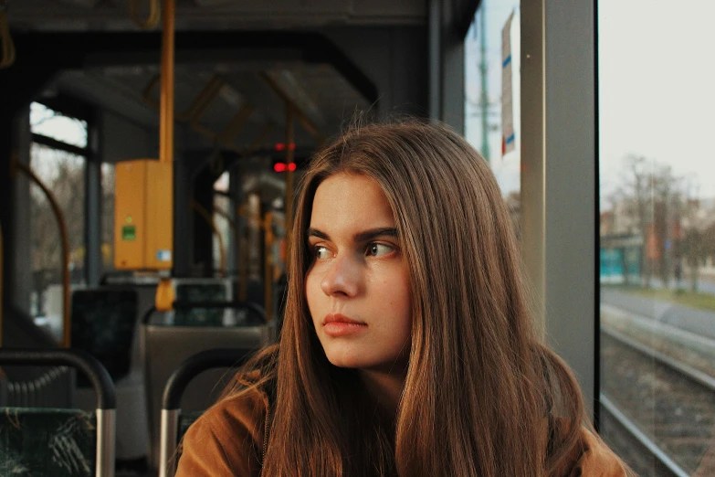 a woman sitting outside on a bus looking at the traffic