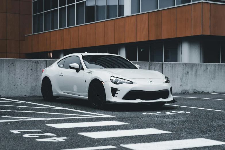 a white toyota sports car parked in a parking lot