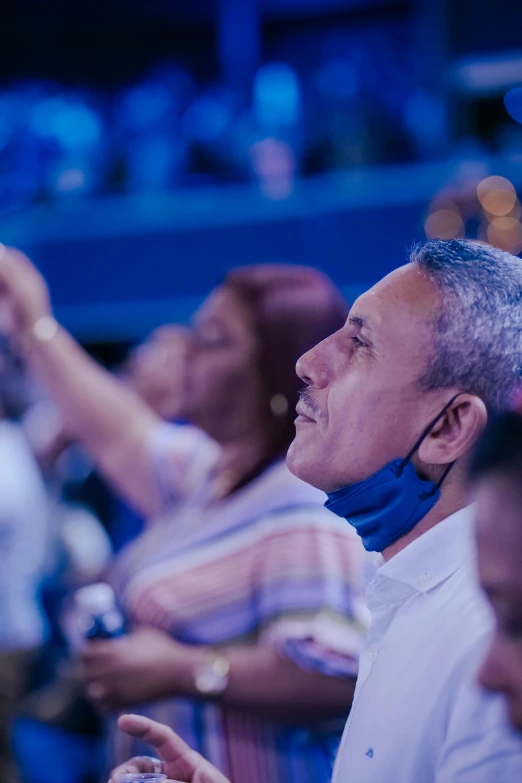 people in a crowd with earplugs on their ears