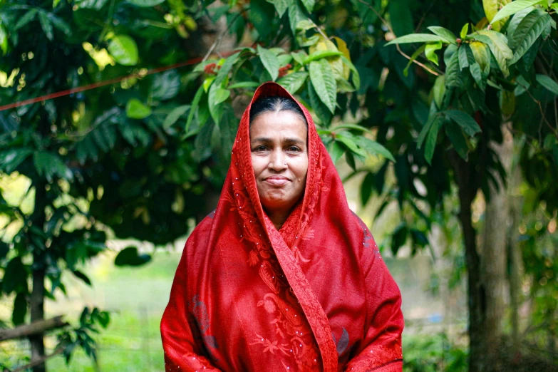 a woman is wearing a red blanket around her neck