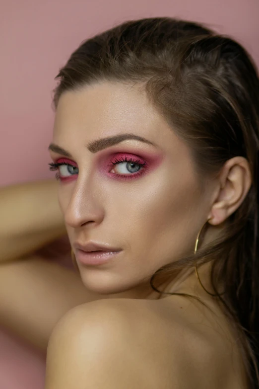 a girl with pink eye makeup and long hair