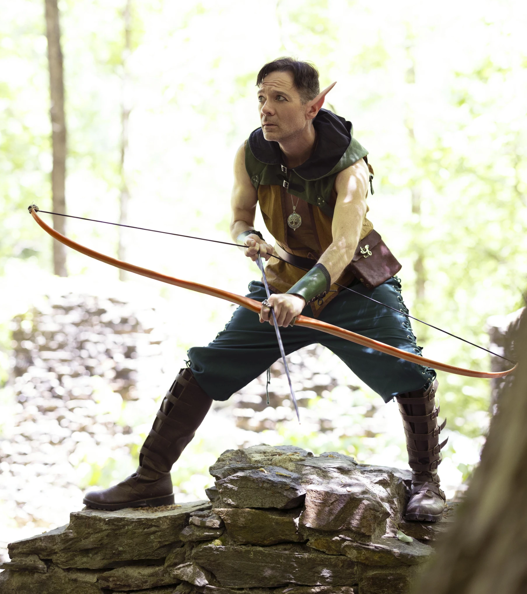 a man in costume holding a bow and arrow