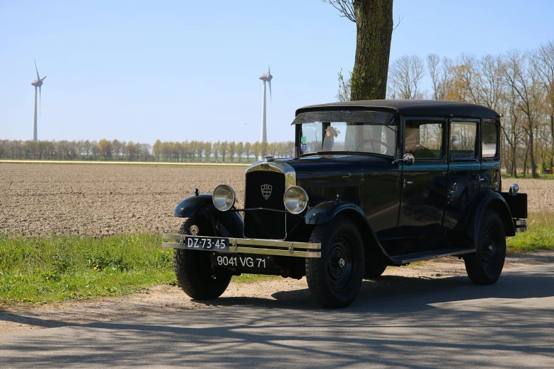 an old fashioned car parked next to a field