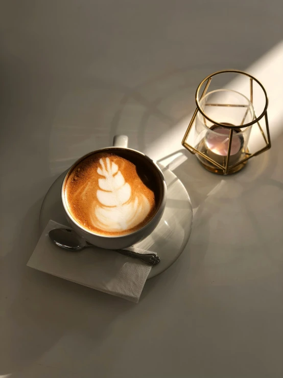 a cappuccino is in a glass cup on a table