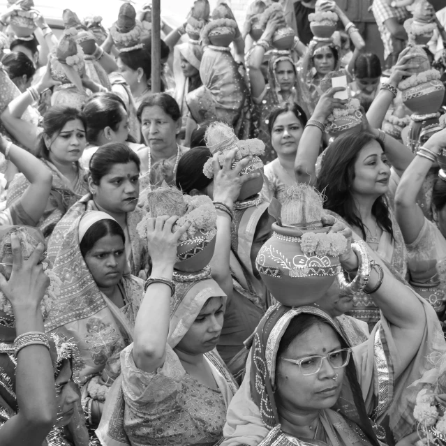 many people in dress holding bowls at the same time