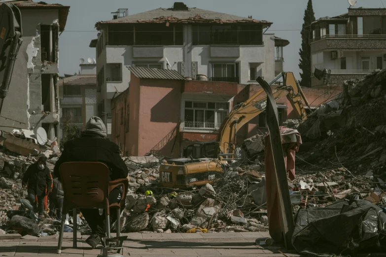 two men in bikes walk past some rubble