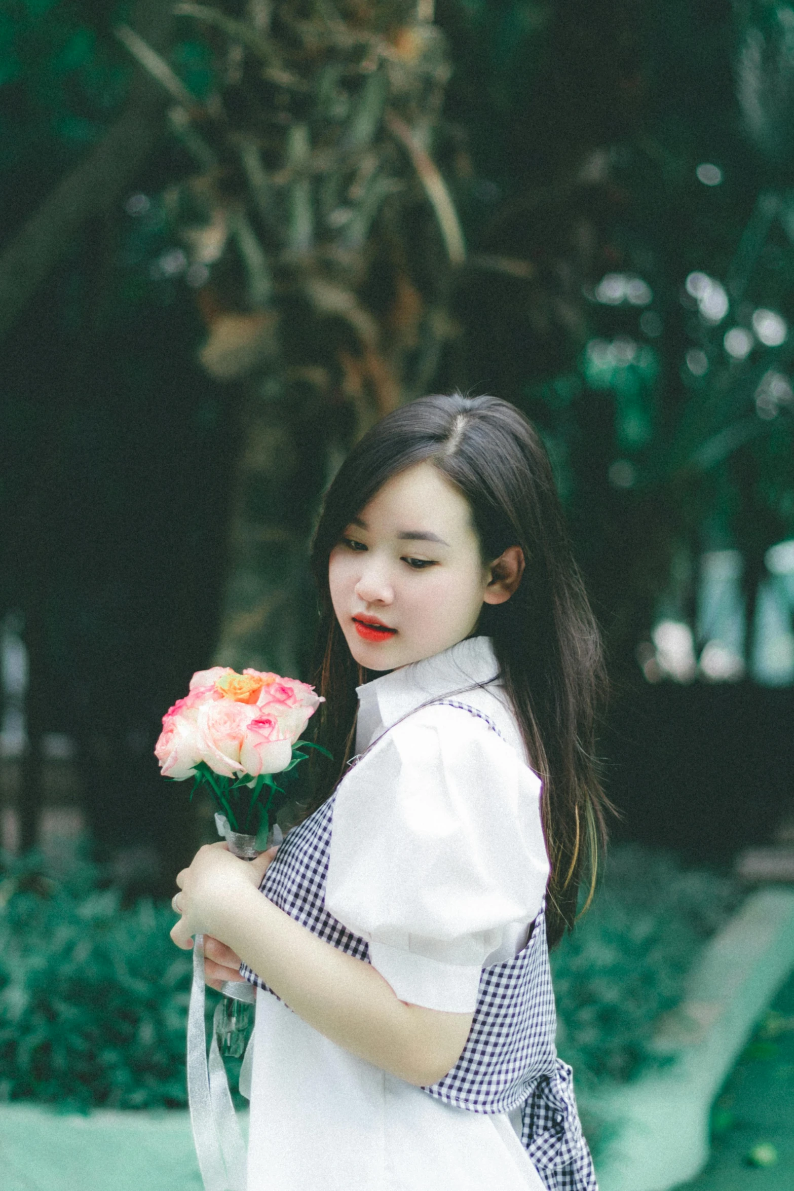 a little girl that is holding flowers and wearing a plaid shirt