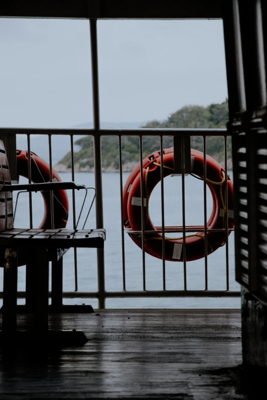 two life buoys sit near a fence by the water