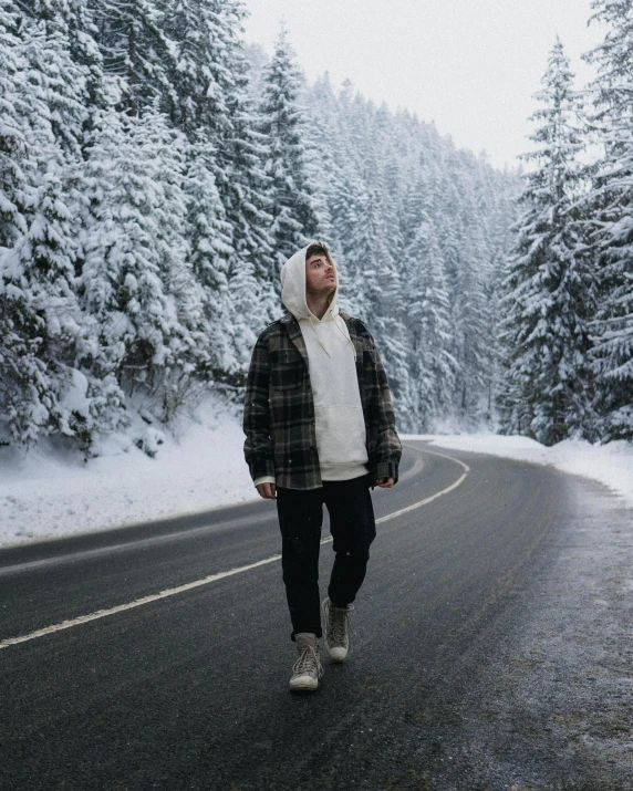 a person walking on a snowy road in a hoodie