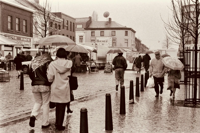 several people are walking in the rain with umbrellas