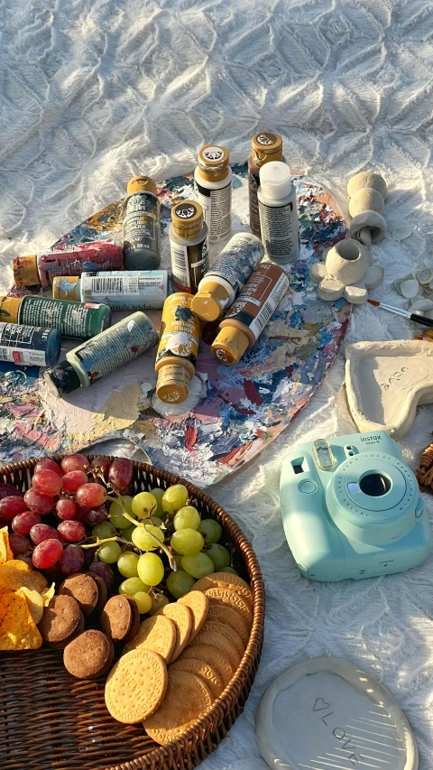 a picnic is set out on the sand with food, beverage and snacks