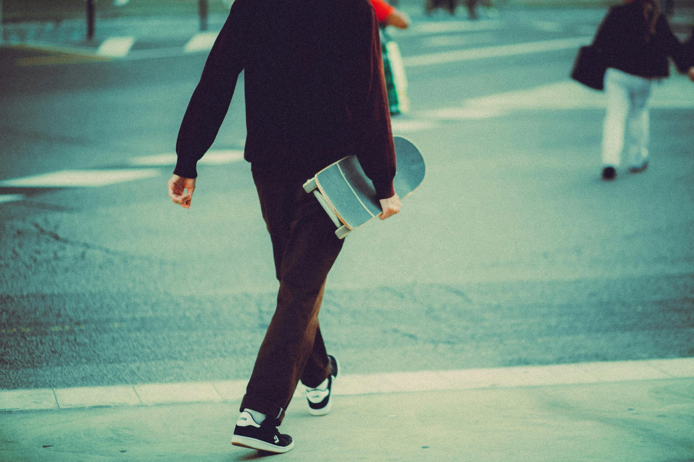 woman in black dress skateboarding down an empty street