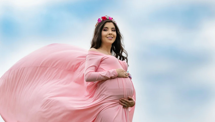 a pregnant woman wrapped in a pink sheet