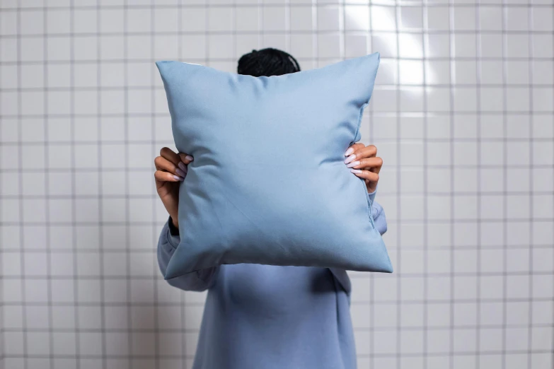 a person holding a large pillow in front of them