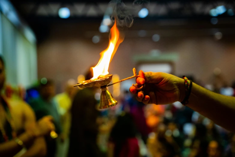 a person holding a metal tea light