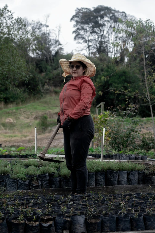 a woman is holding a rake in a garden