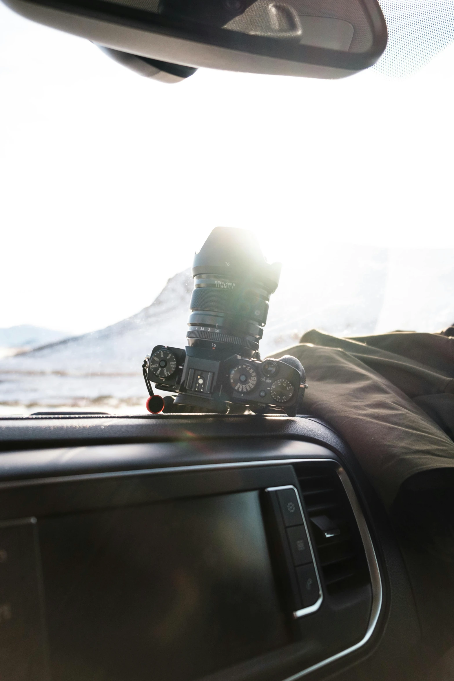 the sun is shining behind a camera set on the dashboard