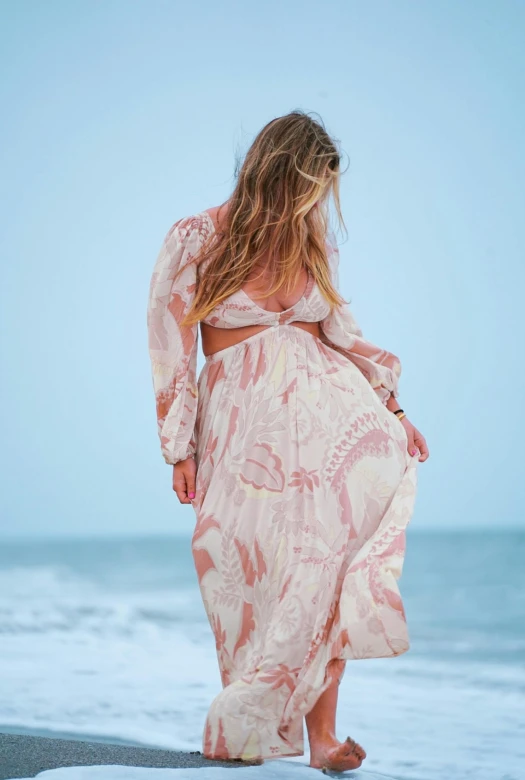 a woman wearing a pink and white printed dress