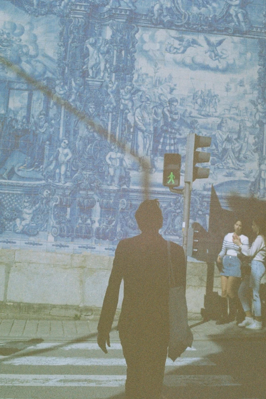 a person crossing a street under a stoplight