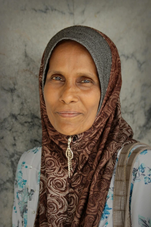 woman in head scarf and a backpack looks to the side