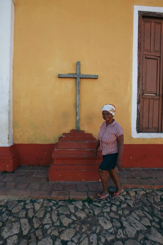 a man stands next to steps leading up to a cross