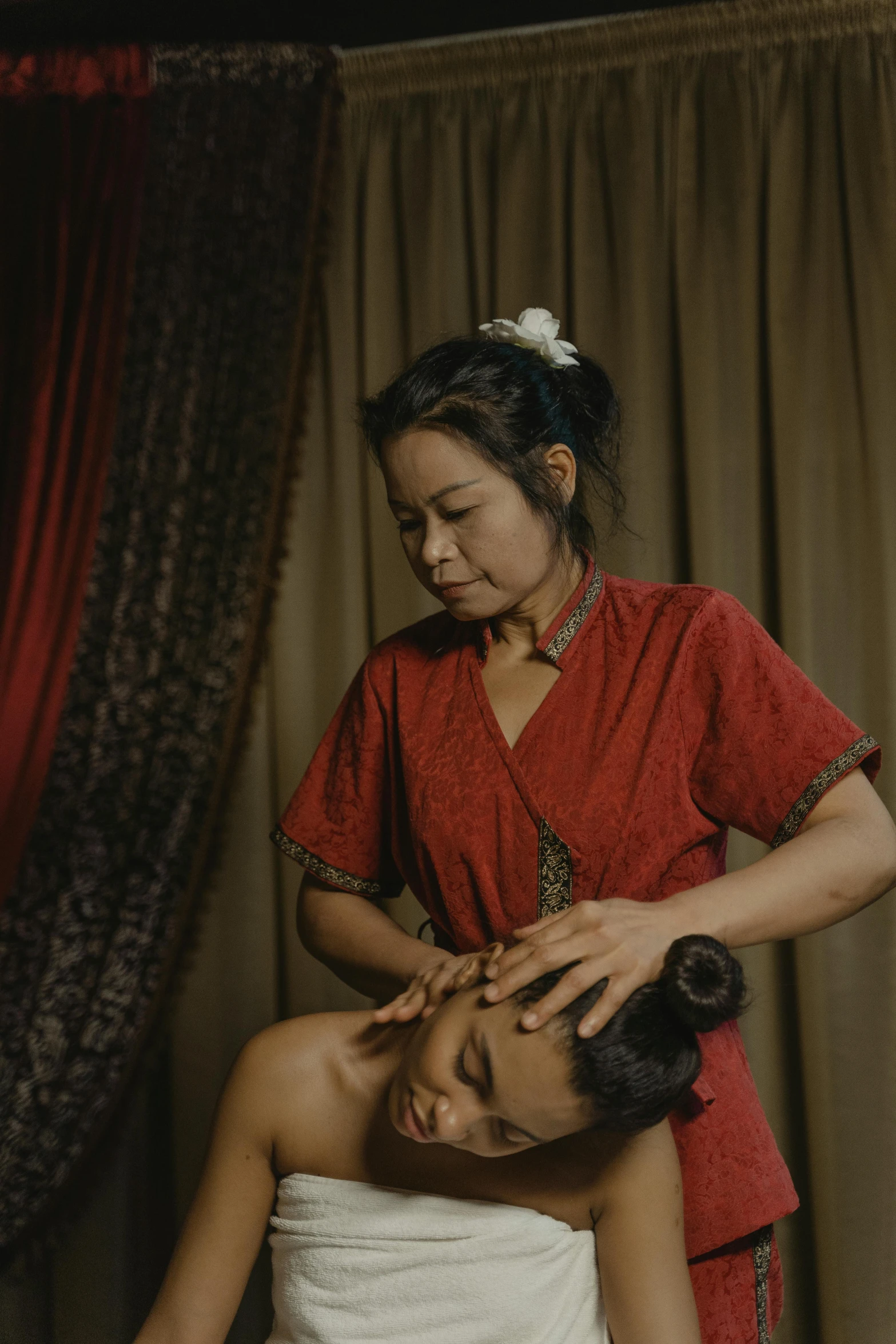 a woman getting her hair done while another lady watches