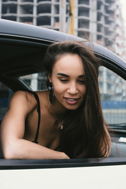 a woman leaning out the car window looking at soing