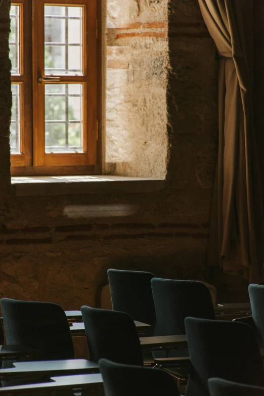 empty chairs line up in front of a small window