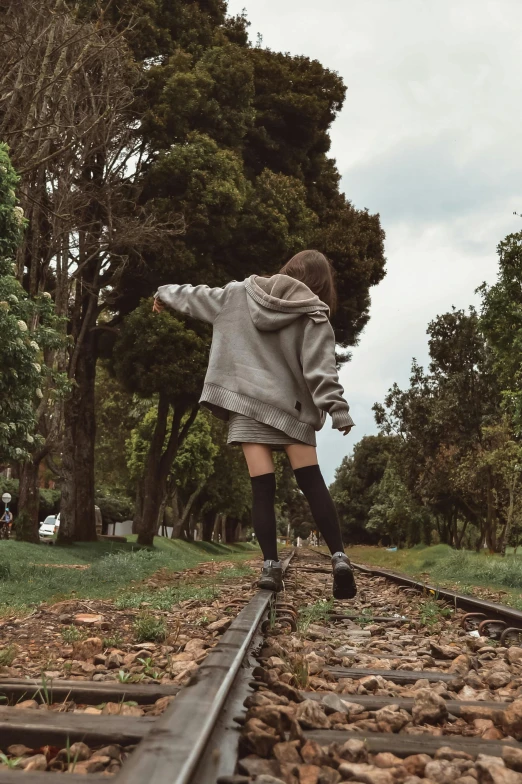 a woman on the train track, in the rain