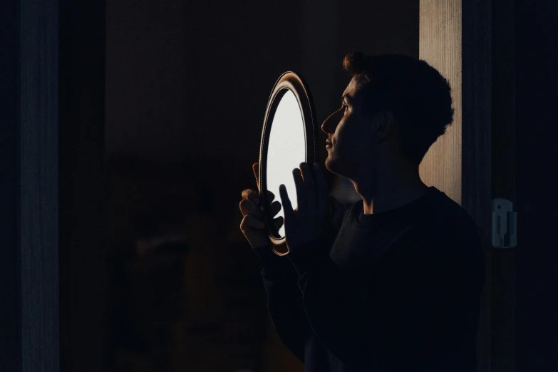 a person looking at a mirror in the dark