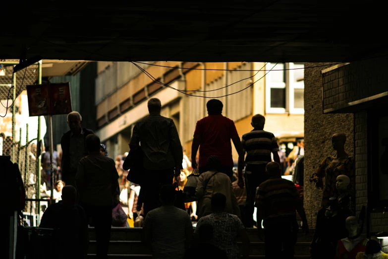 people are standing around looking at soing that is under a bridge