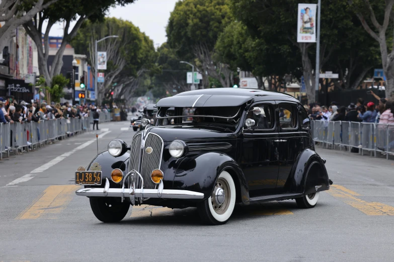 a classic car is being driven down the road