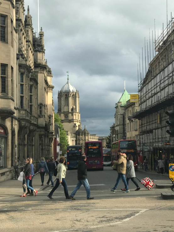 people walking in a street near large buildings