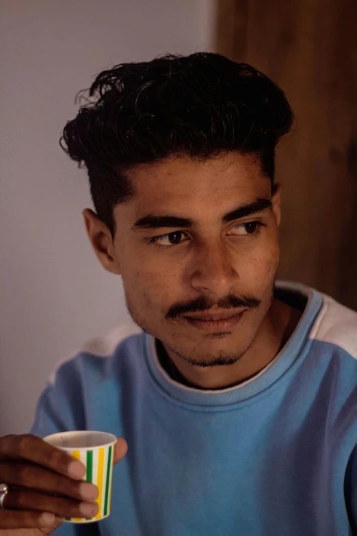 a man is holding his  drink in the cafe